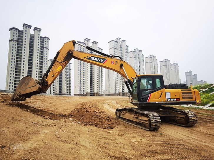 Excavator working on road construction with RTK positioning support.